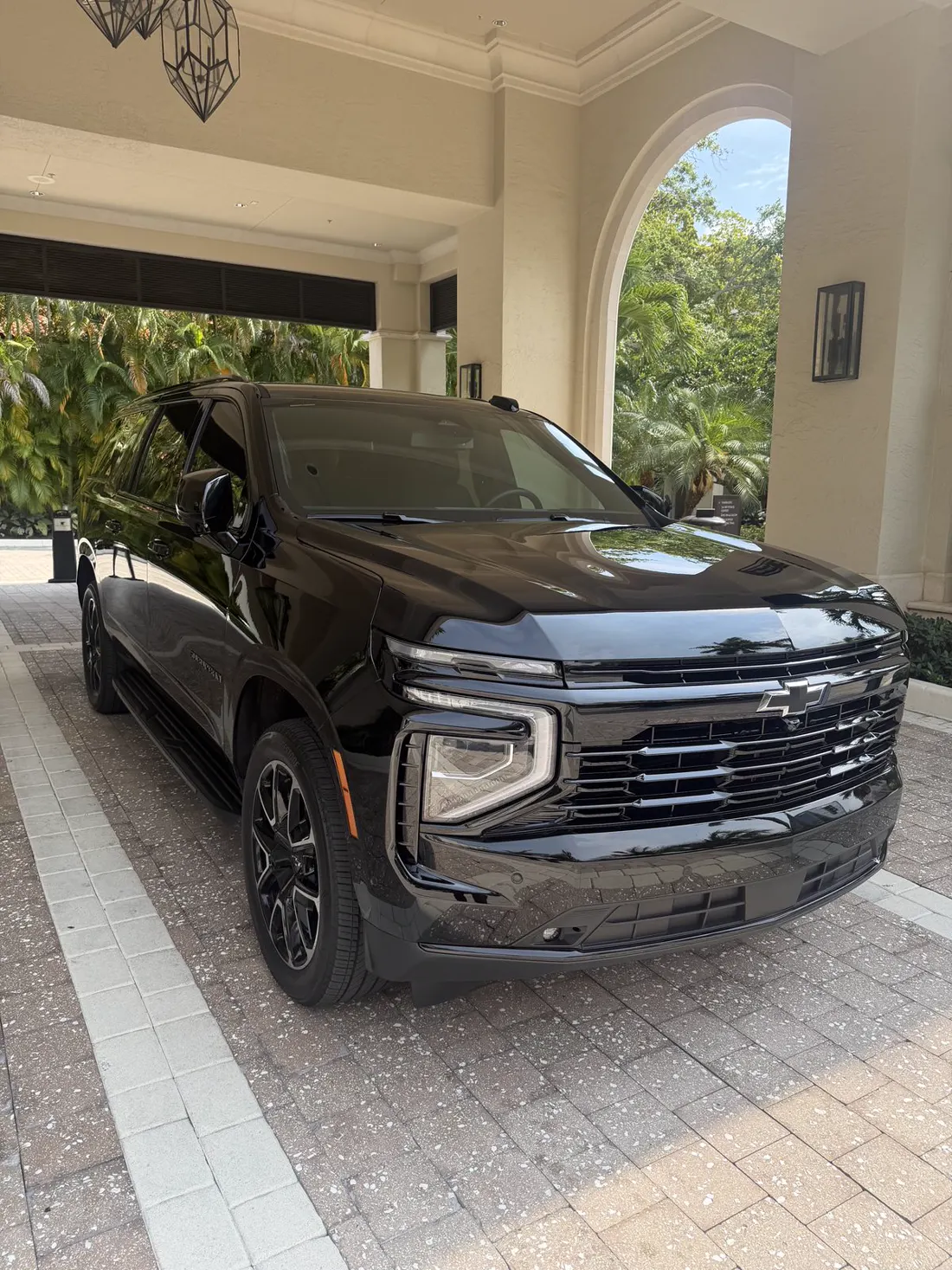 Чёрный Chevrolet Suburban RST 2026, вид спереди в три четверти, у курорта в Южной Флориде