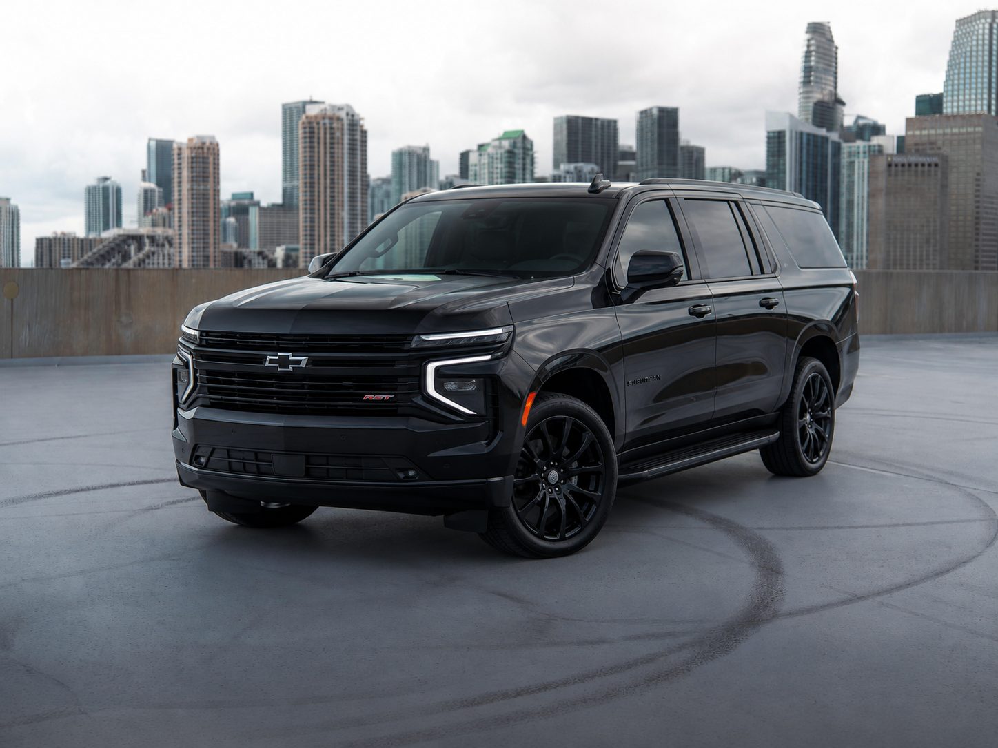 Black Chevrolet Suburban RST staged for a Fontainebleau Aviation private jet ground transfer, Miami skyline behind it