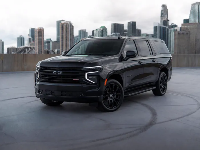 Chevrolet Suburban RST negra en una azotea de Miami con el horizonte del centro al fondo, lista para un traslado a FBO de aviación privada